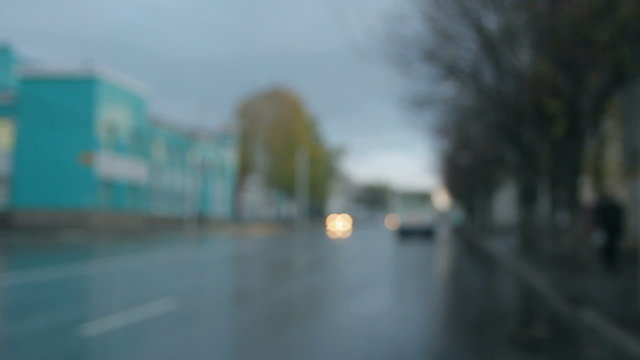 defocused cars moving on street at rain