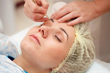 woman having a stimulating facial treatment from a therapist