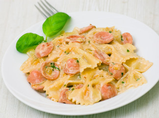 Farfalle pasta with sausage and cream sauce with basil