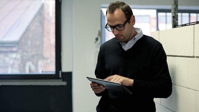 Businessman with tablet computer in the office hall 