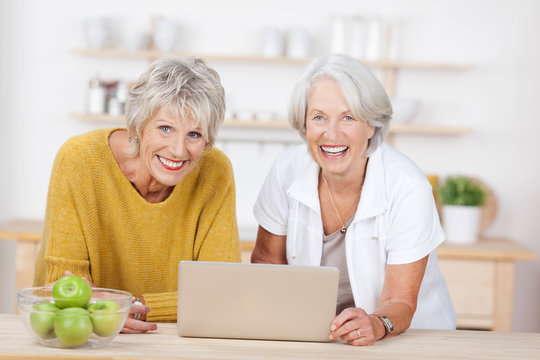 zwei seniorinnen mit laptop in der küche