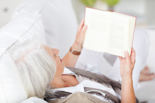 entspannte seniorin liest ein buch