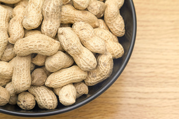 Close up image of peanuts in a black bowl