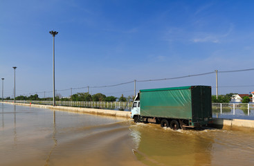 Goods truck try to driving through on flooded road