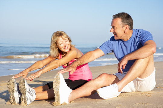 Senior Couple Exercising On Beach