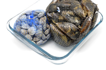 mussels and clams in two net bags on glass bowl