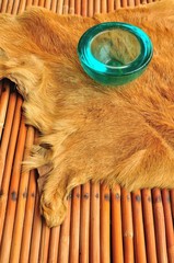 Blue glass ashtray over cow leather and rattan