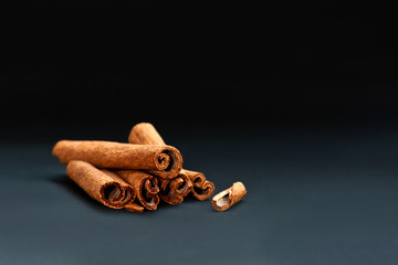 Cinnamon sticks on grey and black background