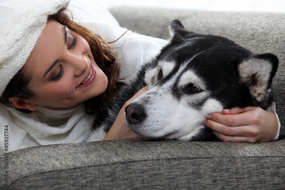 Wall mural young woman cuddling her dog