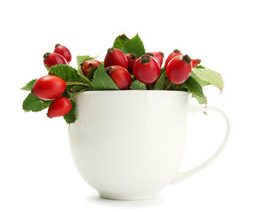 ripe hip roses with leaves in cup, isolated on white
