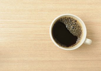 Fresh Black Coffee in a White Ceramic Cup  on a Wooden Table