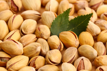 tasty pistachio nuts with leaves, close up