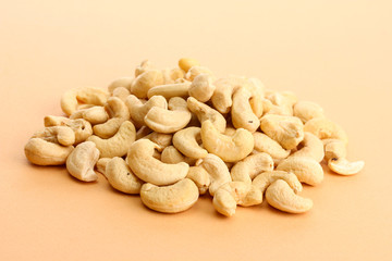 tasty cashews nuts, on beige background