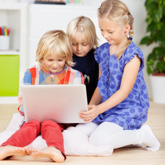 drei mädchen mit laptop im kinderzimmer