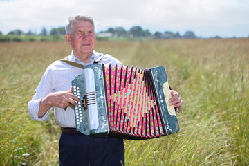 Grandfather in shirt play on accordion