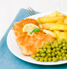 fish and chips with peas and a slice of lemon