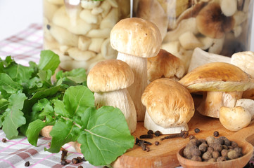 boletus on wooden cutting board, spices, oil and spoon 