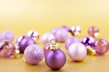 Lila Christbaumkugeln Weihnachtsschmuck auf goldenem Hintergrund