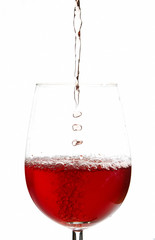 Pale red wine poured slowly into glass
