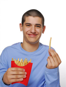 Niño contento comiendo patatas fritas,papas fritas.