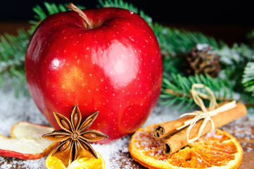 Weihnachtsdekoration mit rotem Apfel und Gewürzen