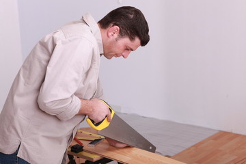 Man sawing laminate flooring