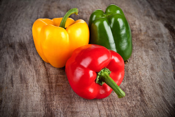 Colored bell peppers on wooden table