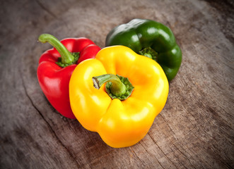 Colored bell peppers on wooden table