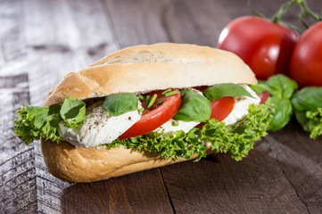 Fresh made Mozzarella Baguette on dark wood