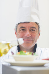 Chef preparing a salad with oil
