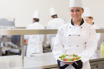 Smiling chef  showing her salad