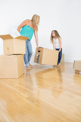 Mother and daughter lifting moving boxes