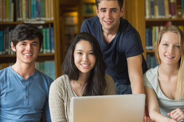 Students sitting at the library while smiling
