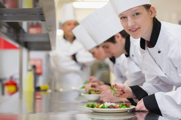Happy chef looking up from preparing salad
