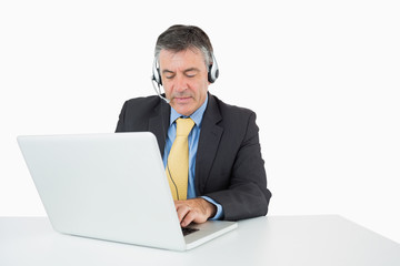 Serious man sitting at his desk with headphones