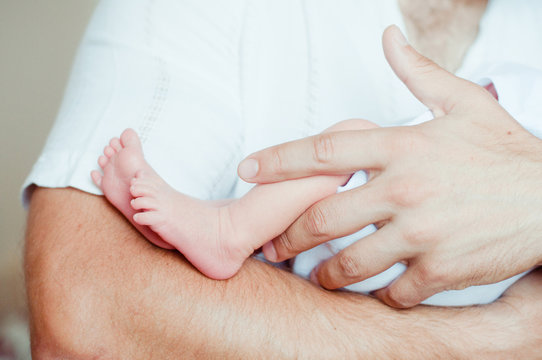 Baby feet on father's hands