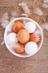 eggs and feathers on wooden table