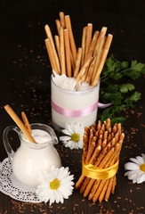 Tasty crispy sticks with pitcher and glass with sour cream