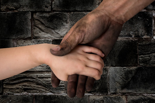 black dirty man hands holding kid clean hand
