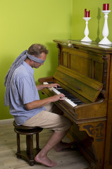 Ein Mann spielt Klavier mit verbundenen Augen