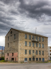 Abandoned factory building under cloudy sky