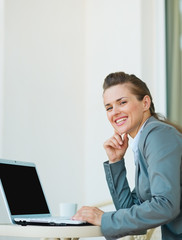 Happy business woman working on laptop