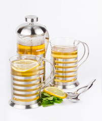 Teapot and cups with tea mint and lemon