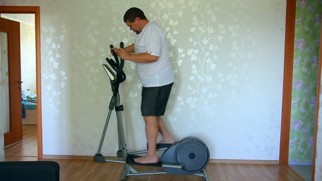 overweight man exercising on trainer ellipsoid