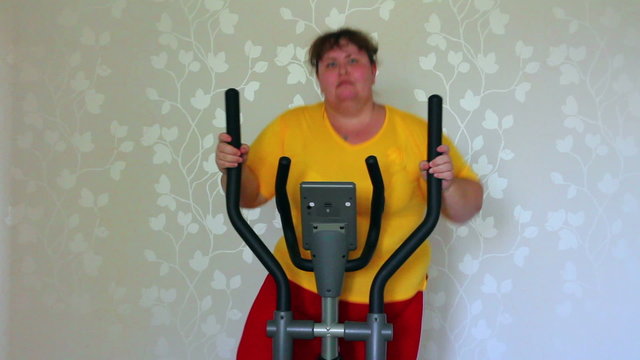 overweight woman exercising on trainer ellipsoid
