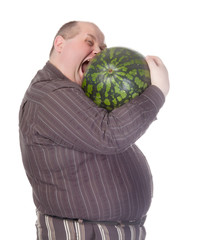 Obese man biting a watermelon