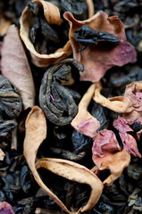 Green tea leaves and dried flowers, close-up, studio shot
