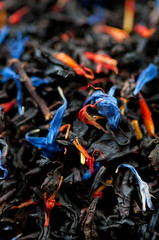 Vertical shot of black tea leaves and dried flowers