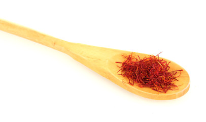 stigmas of saffron in wooden spoon on white background close-up