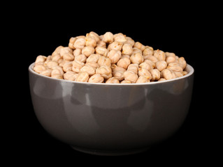 White chickpeas in gray bowl isolated on black